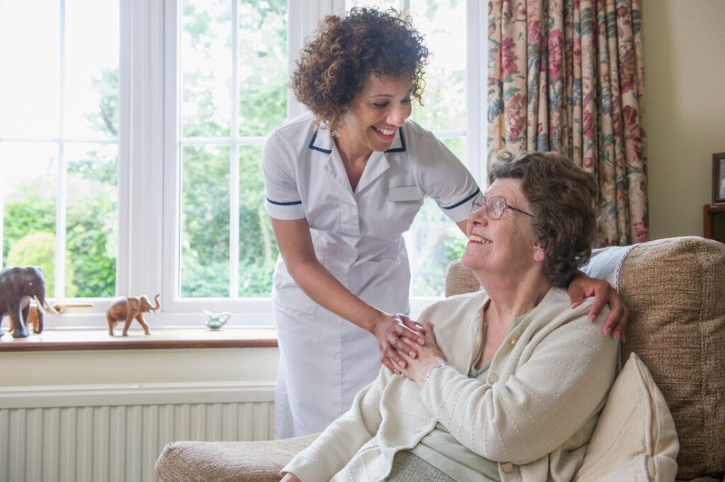 Visiting carer providing personalised home care support to an elderly woman in Hastings.
