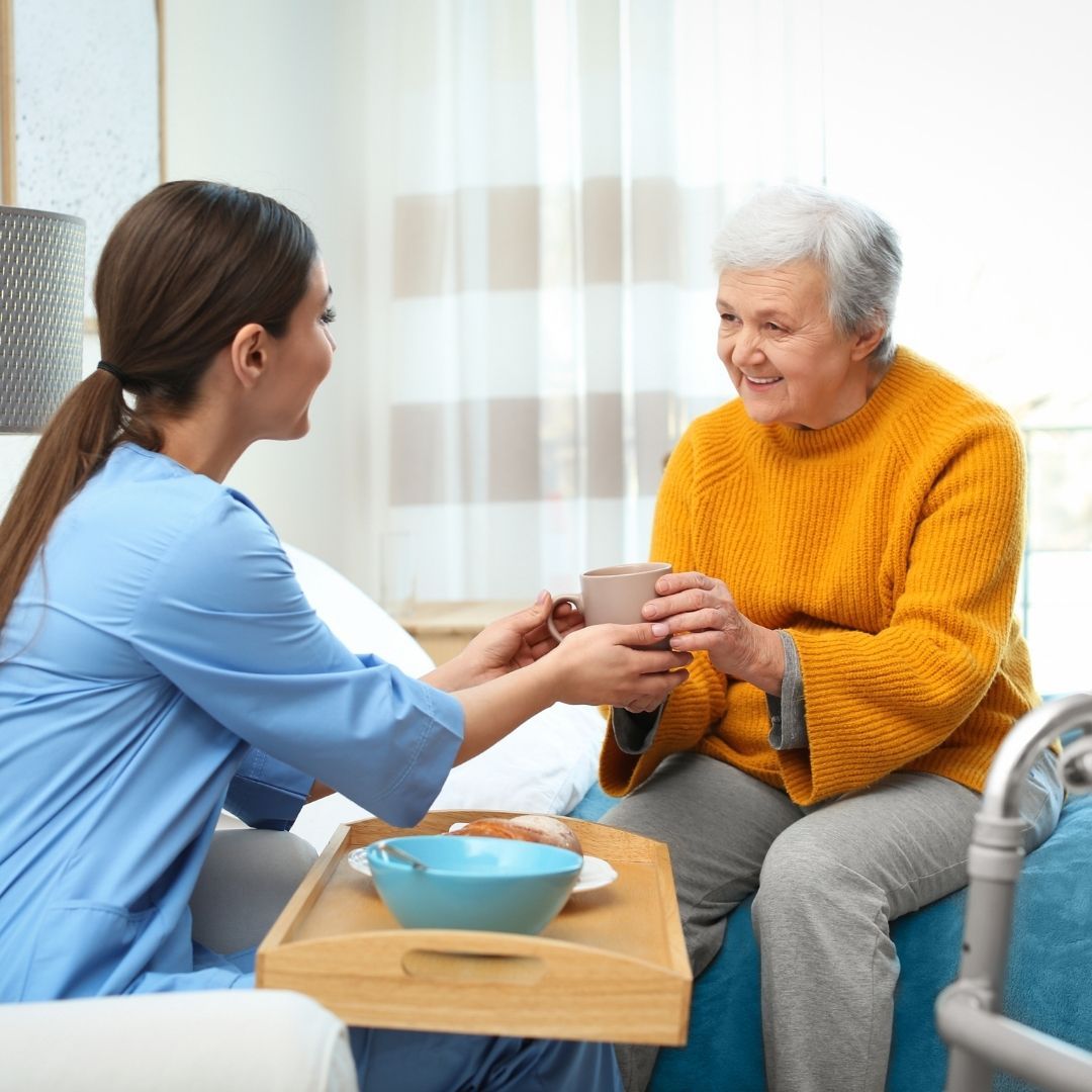 Carer supporting an older client at home in Polegate
